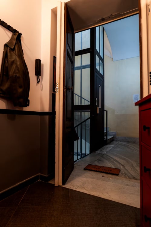 Ingresso moderno di LH51 Rooms a Napoli con porta in vetro nero, pareti beige e design contemporaneo