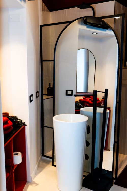 Pod bagno moderno con arredi cilindrici bianchi e struttura nera presso LH51 Rooms, suite dell'appartamento a Napoli