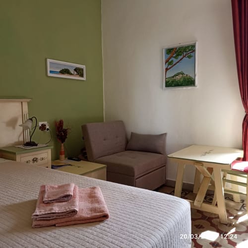 Camera Sarda bedroom at B&B Eleonora D'Arborea in Posada with bed, seating area, and scenic artwork