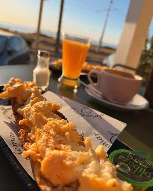 Breakfast at El Chalecito de Alicante: pastries and fresh juice with sea view from hotel terrace