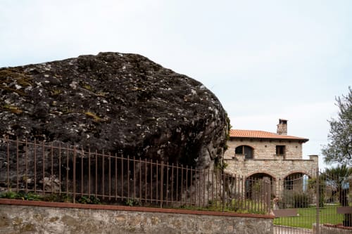 Stone House Gebel el Son B&B con grande masso coperto di muschio dietro recinzione in ferro a Novi Velia, Italia