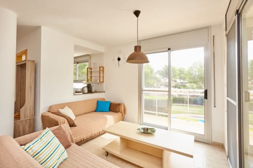 Luminosa sala de estar en Experiencias Encant B&B en Calafat con sofá, muebles de madera y vistas a la terraza