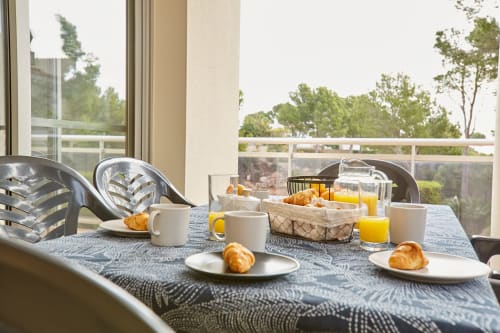 Mesa de desayuno en Experiencias Encant B&B en Calafat con pasteles, café, zumo de naranja y vistas panorámicas de la terraza
