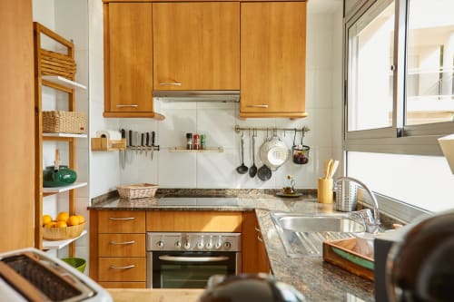Cálida cocina de madera en Experiencias Encant B&B en Calafat con electrodomésticos de acero inoxidable modernos y encimeras de granito