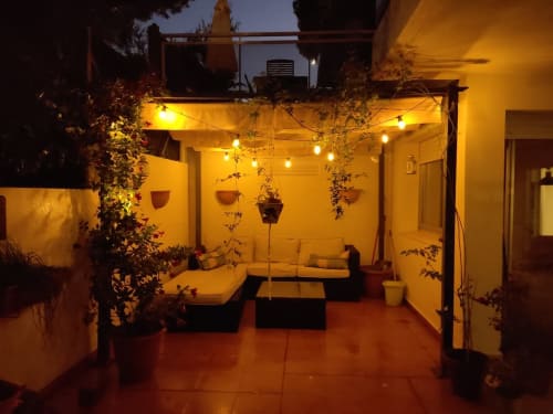 Terraza acogedora en la azotea de Experiencias Encant en Calafat con iluminación cálida, plantas colgantes y área de descanso
