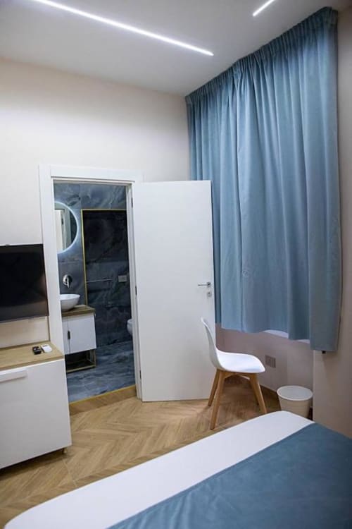 Camera doppia moderna a Dreams & Colors a Napoli con bagno privato, scrivania, TV a schermo piatto e tende blu