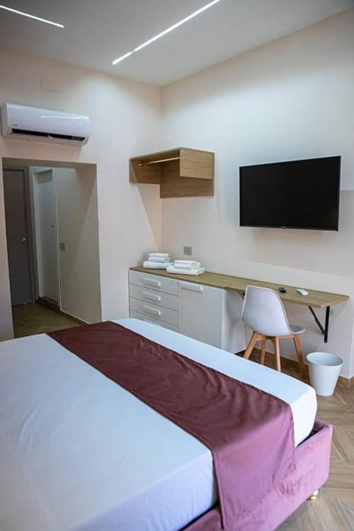 Camera Tripla Moderna presso Dreams & Colors B&B a Napoli con letto, scrivania, TV, condizionatore e accesso al bagno