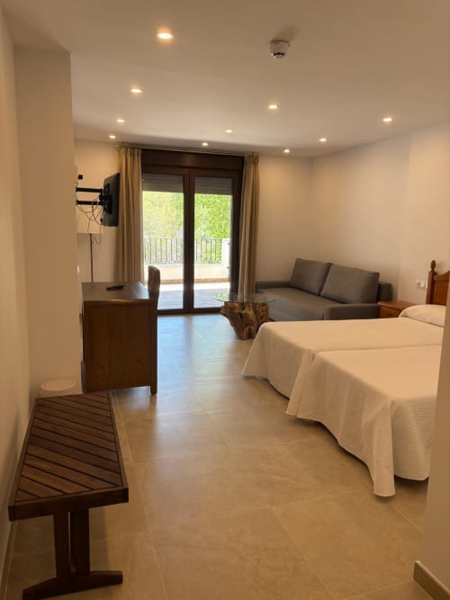 Suite Terraza Río at Hotel Mulhacén Trevélez with twin beds, sofa, balcony overlooking river and mountains near Trevélez,