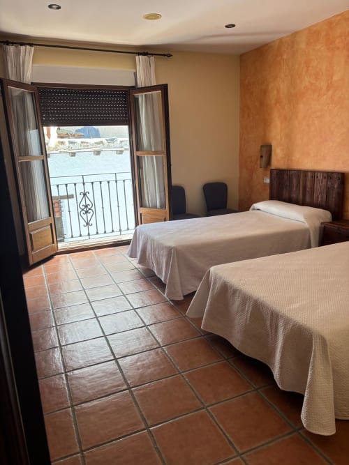 Habitación doble con balcón en Hotel Mulhacén Trevélez, Granada, con suelo de azulejo de barro y vistas al mar