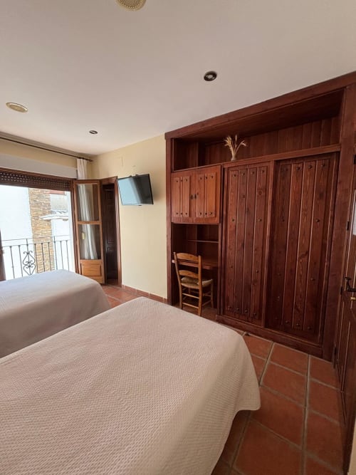 Habitación doble con armario de madera y balcón en Hotel Mulhacén Trevélez, Granada