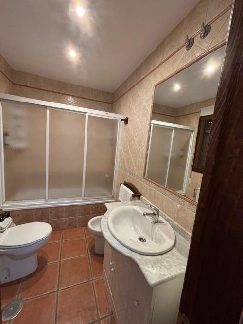 Bathroom in Hotel Mulhacén Trevélez with sink, toilet, shower enclosure and mirror in Granada, Spain