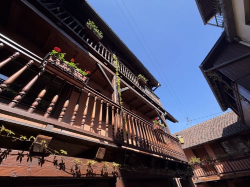 Maison à colombages traditionnelle à l'Hôtel de l'Ange à Niedermorschwihr avec jardinières fleuries et balcons en bois