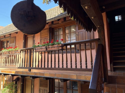 Charmant balcon en bois orné de fleurs rouges à l'Hôtel de l'Ange à Niedermorschwihr, France