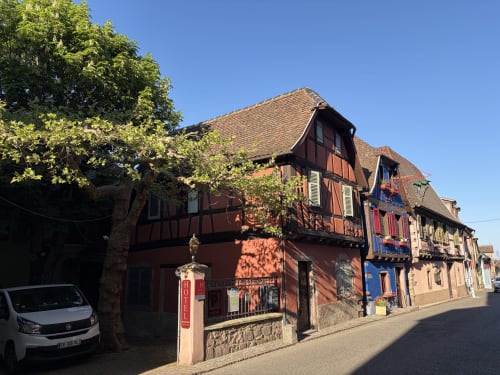 Façade extérieure de l'Hôtel de l'Ange à Niedermorschwihr avec architecture à colombages traditionnelle et façades colorées