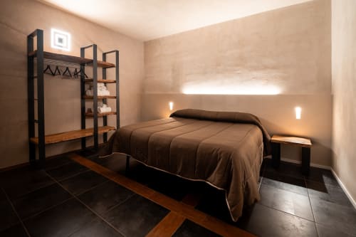Camera da letto moderna a Stone House Gebel el Son a Novi Velia con biancheria marrone, scaffale nero e illuminazione d'ambiente