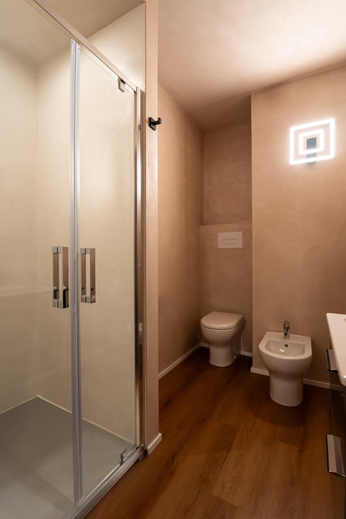 Bagno moderno nella Stone House Gebel el Son con doccia, WC, bidet e pavimentazione in legno a Novi Velia