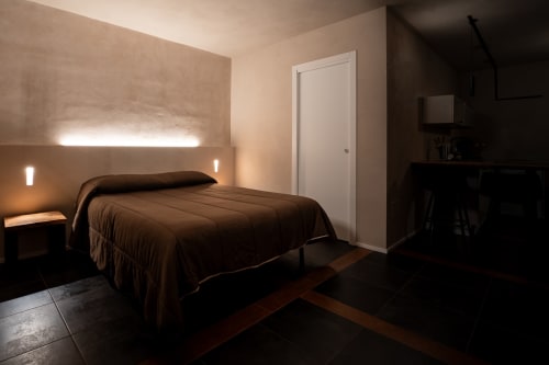 Camera da letto moderna a Stone House Gebel el Son a Novi Velia con biancheria marrone, illuminazione d'accento e vista sul giardino