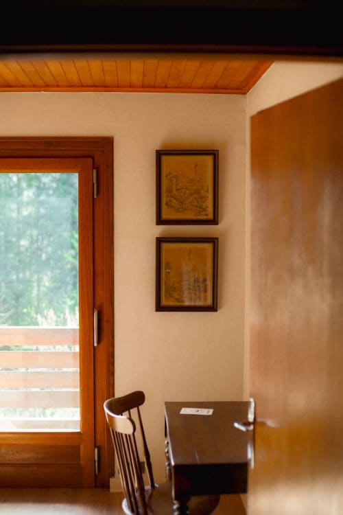 Chalet Viñales room with wooden door, framed artwork, and chair overlooking Les Houches