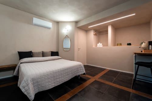 Camera matrimoniale moderna presso Stone House Gebel el Son a Novi Velia con letto trapuntato bianco, pareti rosa e pavimenti in scuro