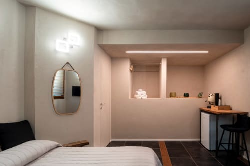 Camera da letto matrimoniale moderna a Stone House Gebel el Son a Novi Velia con letto, specchio ovale, scrivania e illuminazione ambientale