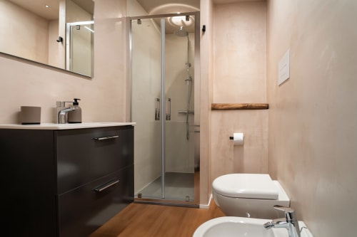 Bagno moderno a Stone House Gebel el Son con doccia walk-in, mobile scuro e pavimentazione in legno