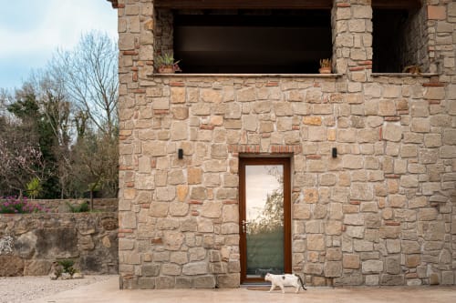 Casa in pietra Gebel el Son a Novi Velia, con muratura rustica e gatto bianco sul patio in terracotta