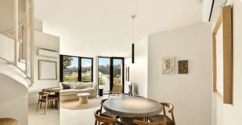 Modern apartment living area at Casa Redonda Aroeira with dining table, garden views, natural light, and contemporary