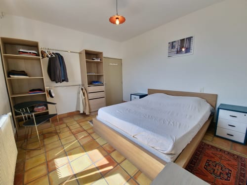 Bright bedroom at Smooth Luberon in Villars with wooden bed, built-in wardrobe, and terracotta tile flooring