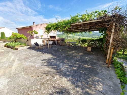 Pergola rustique aux poutres en bois et vignes sur la terrasse avec vue sur les montagnes du Luberon à Smooth Luberon, Villars