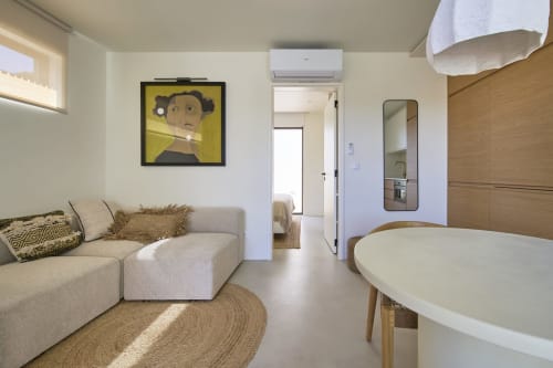 Moderno estúdio em Casa Redonda Aroeira com sofá bege, mesa redonda e vista para a piscina em Portugal