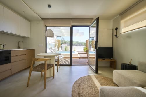 Apartamento de estúdio moderno na Casa Redonda Aroeira com cozinha aberta, sala de jantar, vista da piscina através de portas de vidro