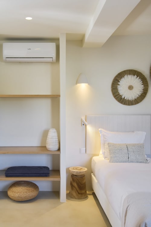 Modern studio bedroom at Casa Redonda Aroeira with built-in shelving, air conditioning, and garden view lighting