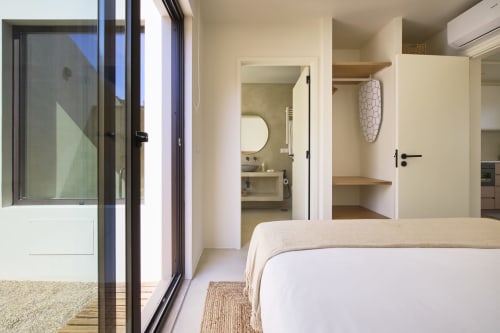Modern bedroom in Casa Redonda Aroeira bungalow with pool view, ensuite bathroom, and garden access