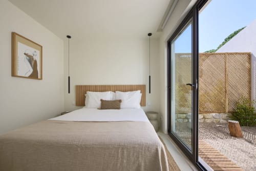 Modern bedroom at Casa Redonda Aroeira with queen bed, garden views, and access to private patio