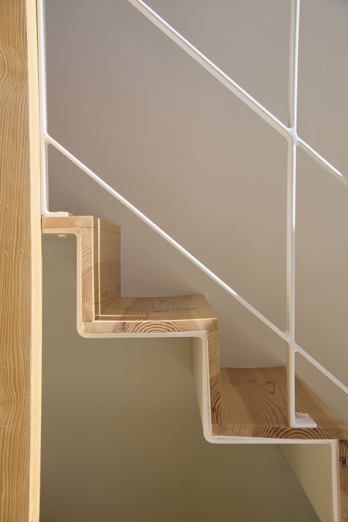 Minimalist wooden staircase with white railings in Casa Redonda Aroeira duplex apartment, Portugal