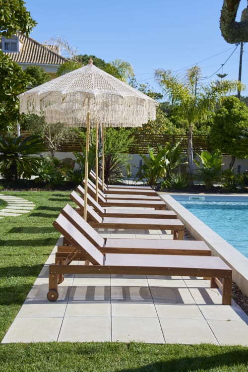 Poolside lounge chairs with cream fringe umbrella at Casa Redonda Aroeira villa in Portugal
