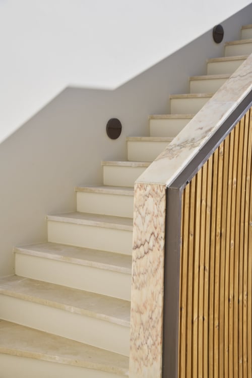 Modern staircase with marble handrail and wooden railings at Casa Redonda Aroeira villa in Portugal