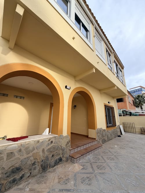 Entrada exterior del hotel El Chalecito de Alicante con arcos curvados y detalles de piedra