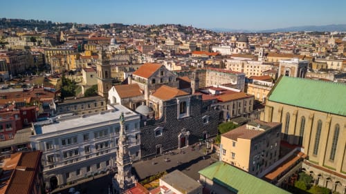 Vista aerea del suggestivo centro storico di Napoli con edifici colorati, chiese e tetti in coppi rossi presso Dreams & Colors B&B