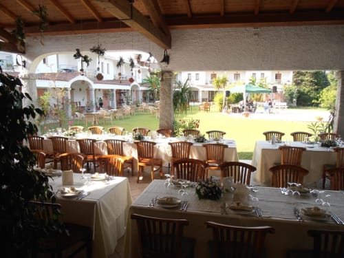 Elegante padiglione esterno per cena al Hotel Ristorante Domu Incantada di Muravera con tavoli preparati, sedie in legno e giardino curato