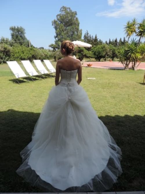 Sposa in abito bianco ammira i giardini curati dell'Hotel Ristorante Domu Incantada a Muravera