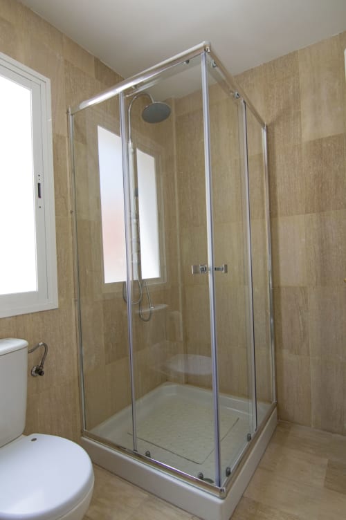 Elegante cabina de ducha de vidrio con alcachofa de techo en el baño de la casita Casa Doñana, Sanlúcar de Barrameda