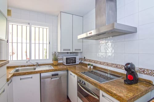 Cocina moderna en Casa Doñana de Living Sur, Sanlúcar de Barrameda, con encimeras de granito y acero inoxidable