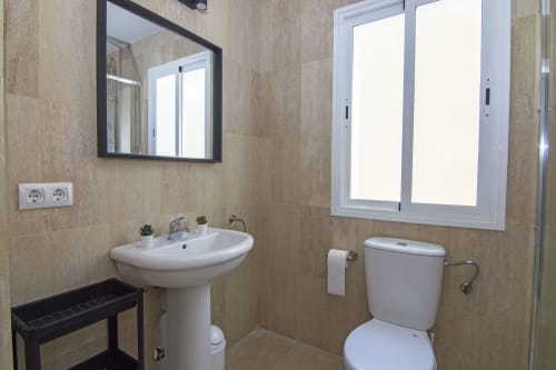 Baño moderno en la cabaña Casa Doñana de Living Sur, Sanlúcar de Barrameda, con lavamanos pedestal, inodoro y ventana