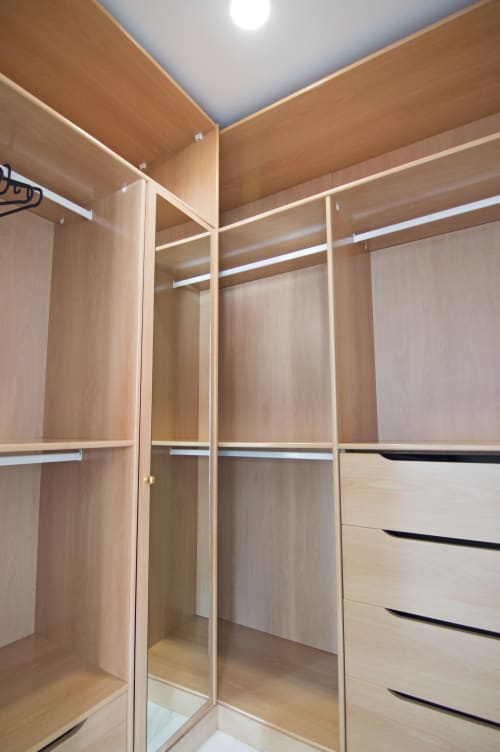 Amplio armario de madera con puertas espejadas, estantes y cajones en la cabaña Casa Doñana de Living Sur, Sanlúcar de