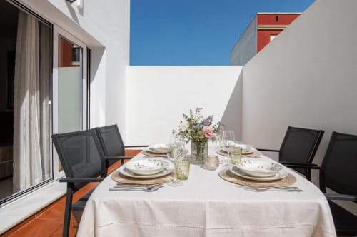 Comedor en terraza al aire libre de Casa Doñana, cottage Living Sur en Sanlúcar de Barrameda con mesa servida y vistas a la ciudad