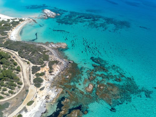 Aerial view of turquoise Mediterranean waters and white sandy beach near Hotel Domu Incantada in Muravera, Italy