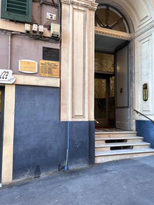 Ingresso del complesso residenziale Le Due Piazze a Genova con porta blu e scalinata in marmo, numero civico 2