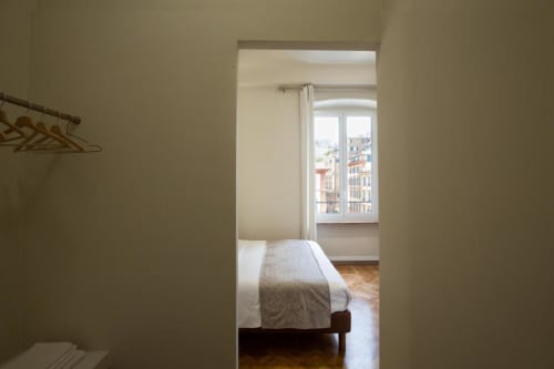 Ingresso camera da letto nell'appartamento Le Due Piazze a Genova, con vista sul letto e la città dalla finestra