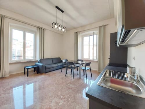 Moderno appartamento open-plan a Genova con cucina, zona pranzo, divano e finestre con vista sulla città